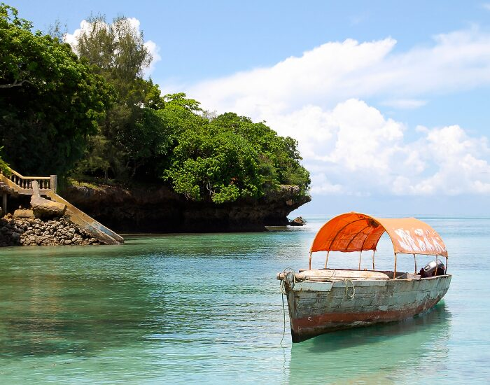 a boat next to the beach on a island