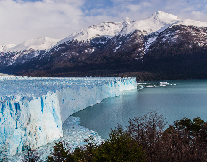 Tierra del Fuego panoramic landscape photo showing a glacier, the ocean and big mountains on the background