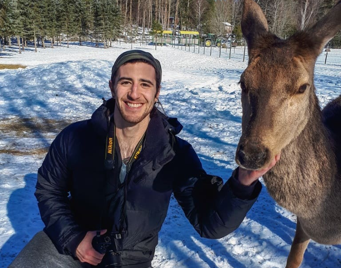 cesar-medina-davila-with-deer.webp a man with a deer in winter