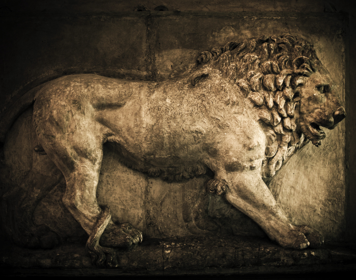 n ancient Roman stone relief carving depicting a walking lion.