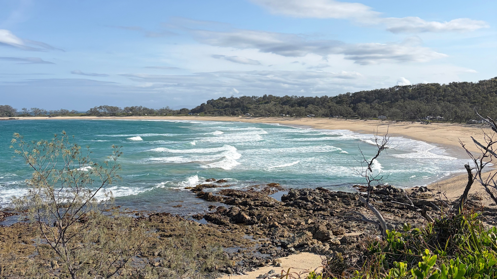 a panoramic view of pebbly beach shwoing the beach and sand dunes