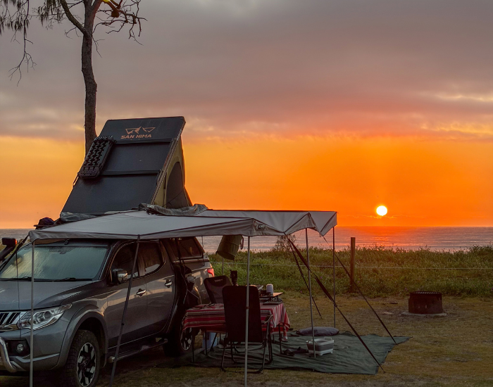 car with roof tent camping at pebbly beach photo by cesar medina davila