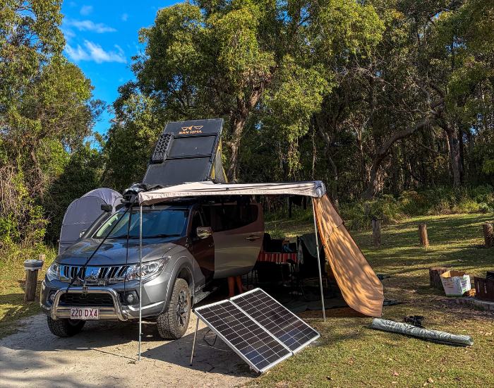 a car with a rooftent and a solar panel camping in illaroo campground