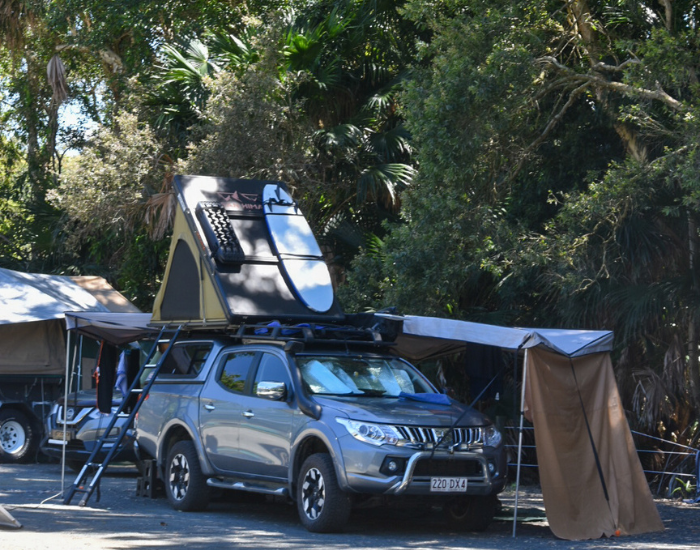 a car with a roof tent in a national park