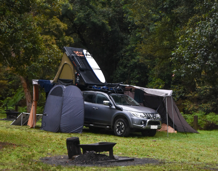 a truck with a roof tent and camping set up in gloucester river campground